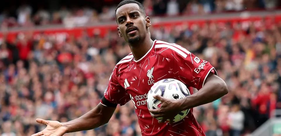 Player in Liverpool kit holding a football