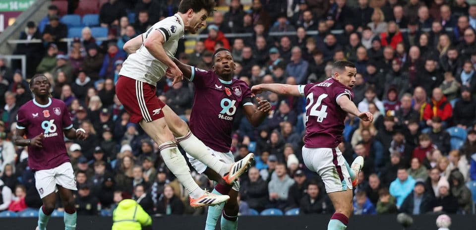 Arsenal player heads ball against Burnley defenders