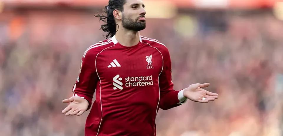 Player in red Liverpool kit gesturing on the pitch