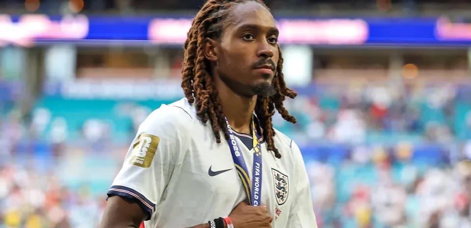 Player wearing England jersey with medal walking on field