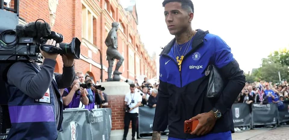 Player arriving at stadium surrounded by photographers