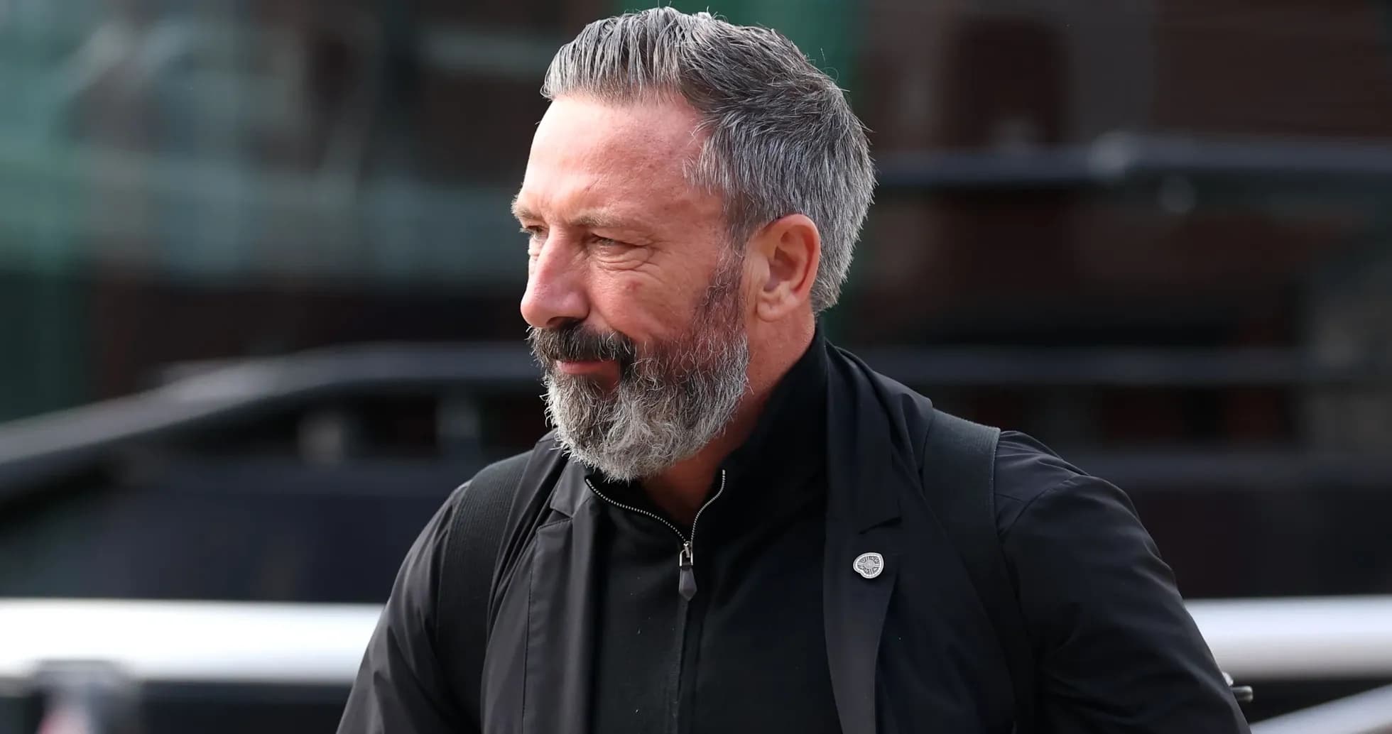 Man with gray beard walking outdoors