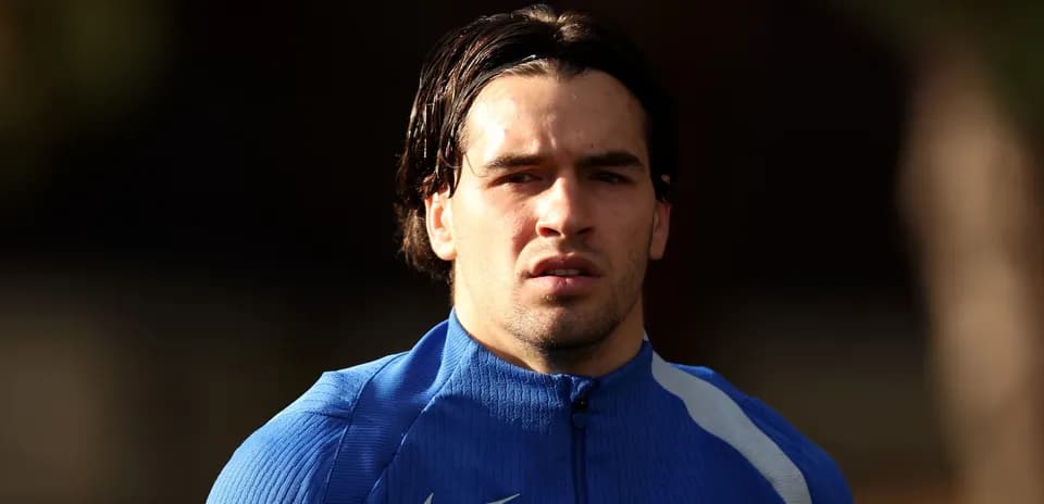 Football player in blue training kit looking forward