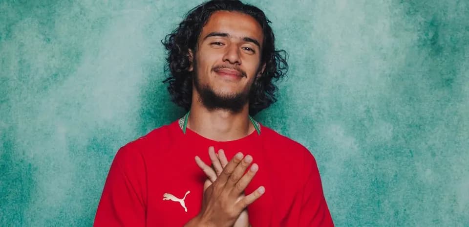 Player posing with hands clasped in red jersey