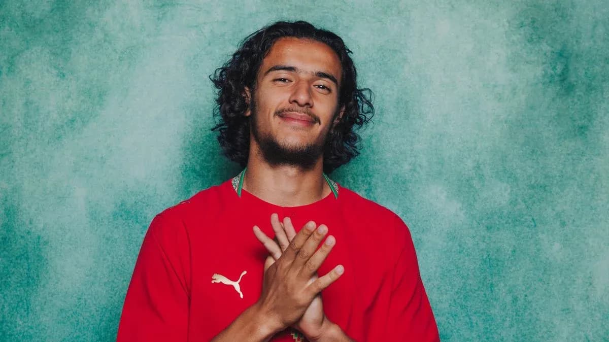 Player posing with hands clasped in red jersey