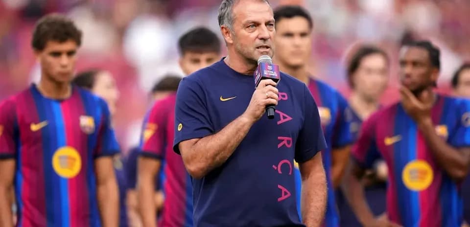 Coach speaking at event with Barcelona players behind