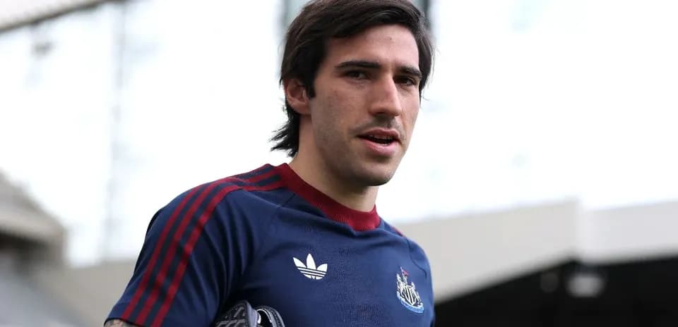Player wearing Newcastle kit at stadium entrance