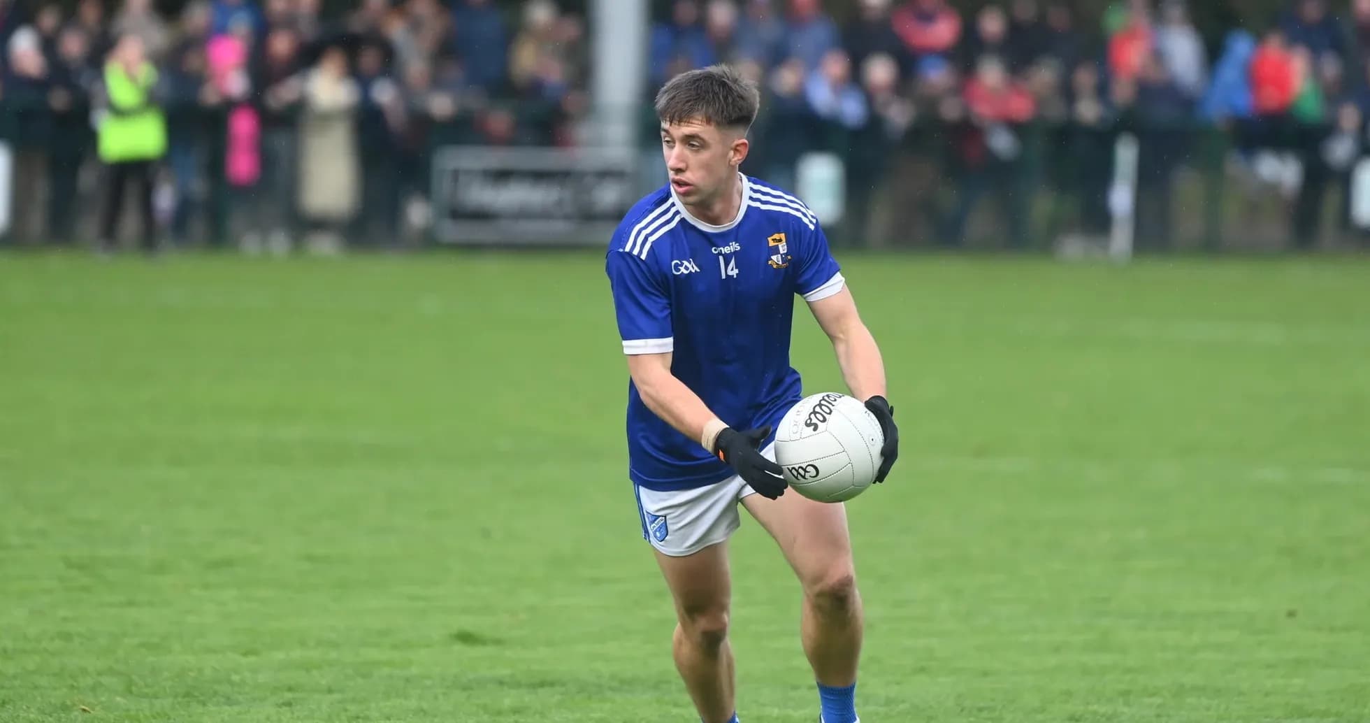 Player in blue jersey holding a Gaelic football