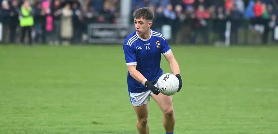 Player in blue jersey holding a Gaelic football