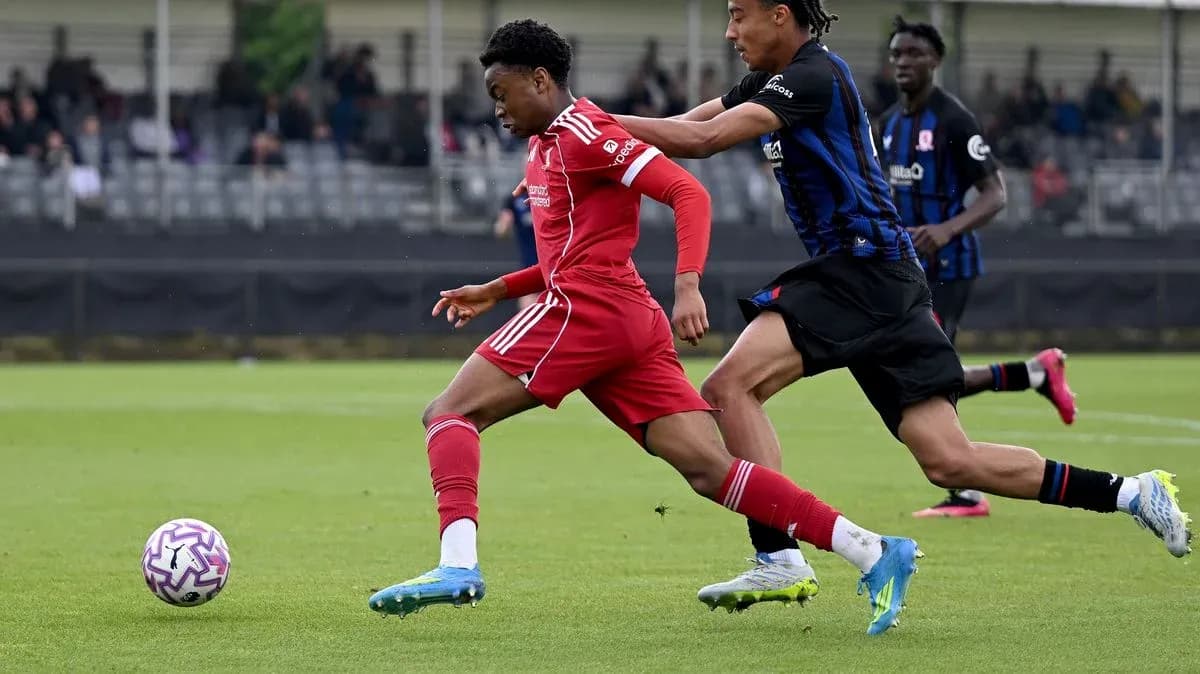 Player in red dribbling past opponent in black