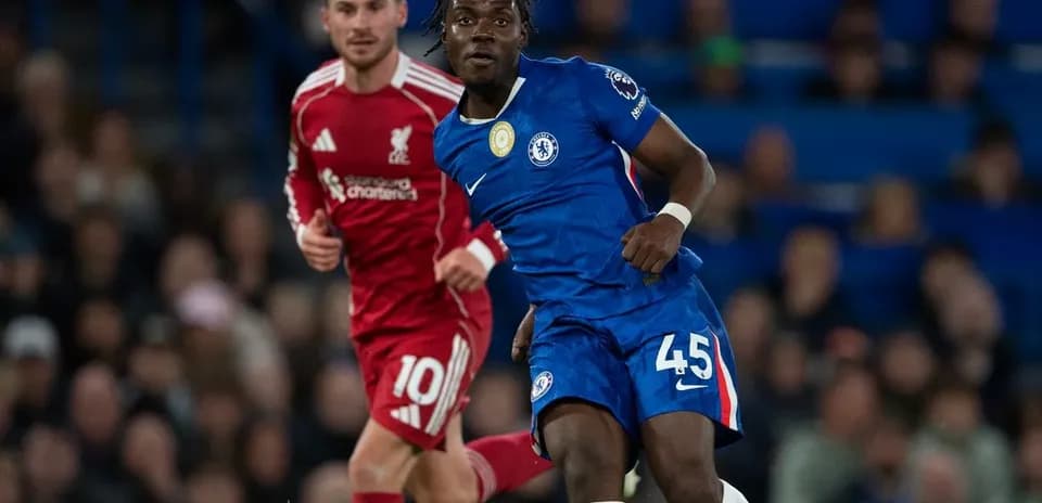 Chelsea player in blue jersey evading Liverpool player