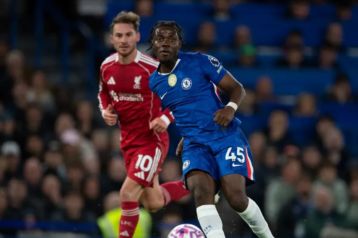 Chelsea player in blue jersey evading Liverpool player
