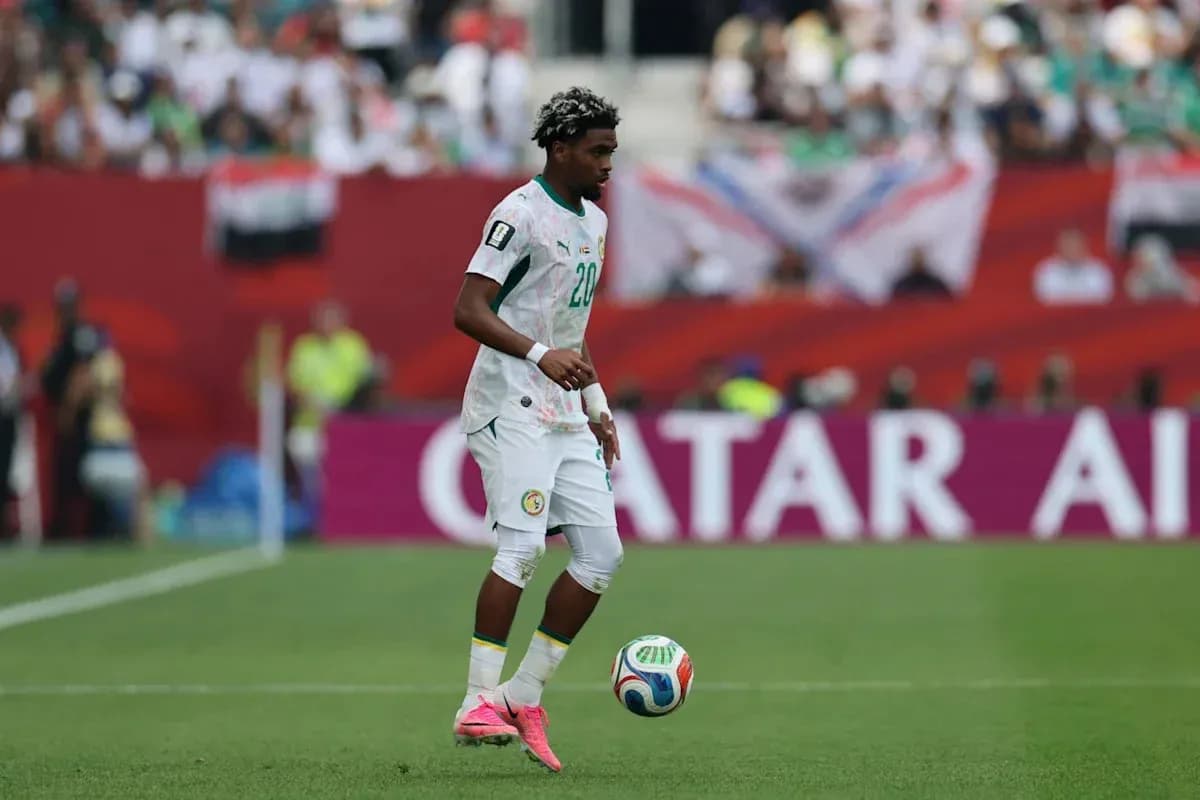 Player in Senegal kit controlling the ball on field