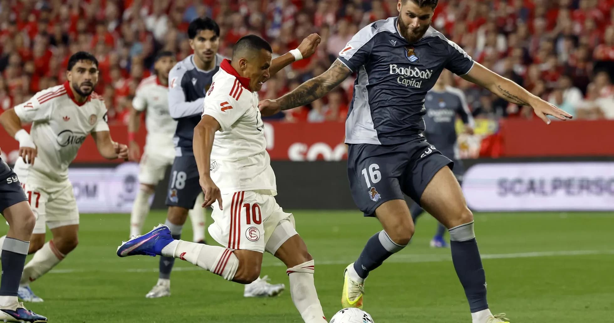 Sevilla player dribbling past Real Sociedad defender