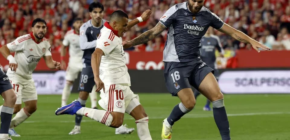 Sevilla player dribbling past Real Sociedad defender