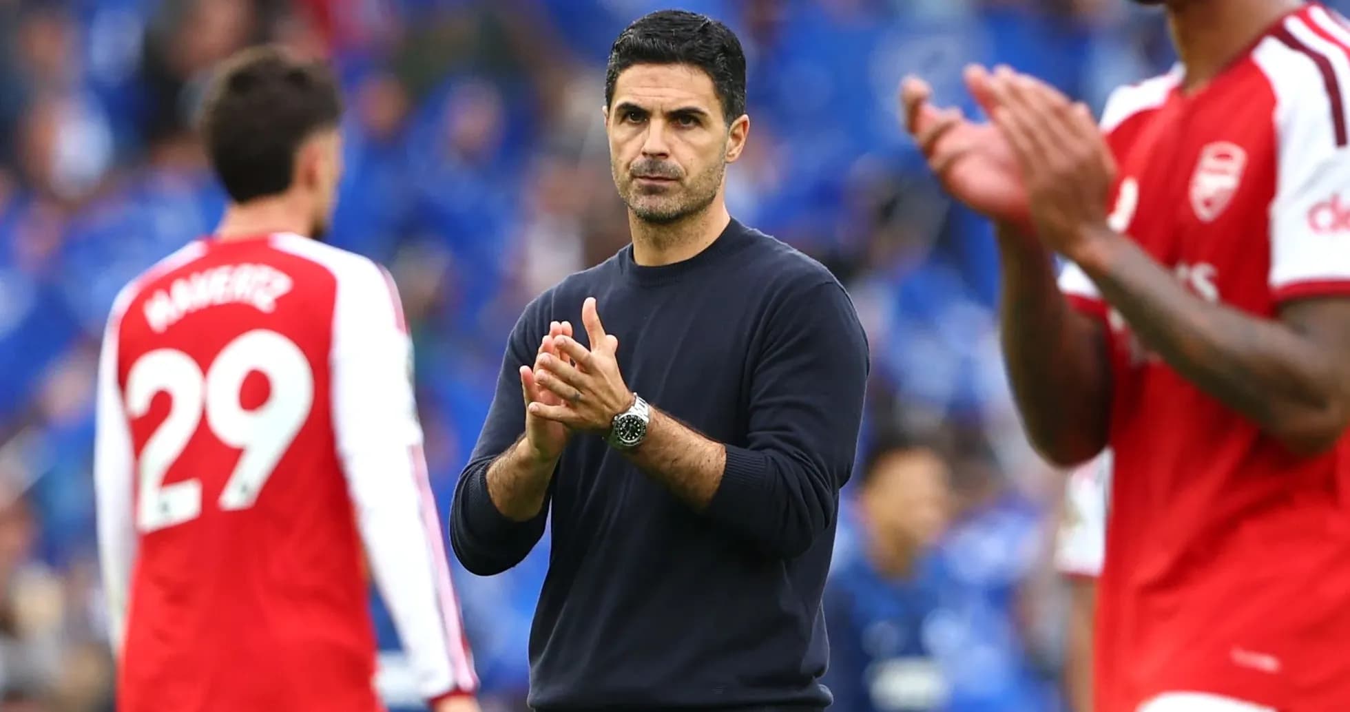 Manager clapping during match with players in background