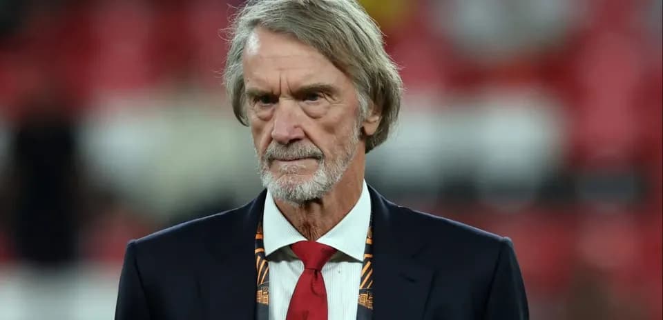 Man in suit with a red tie at stadium