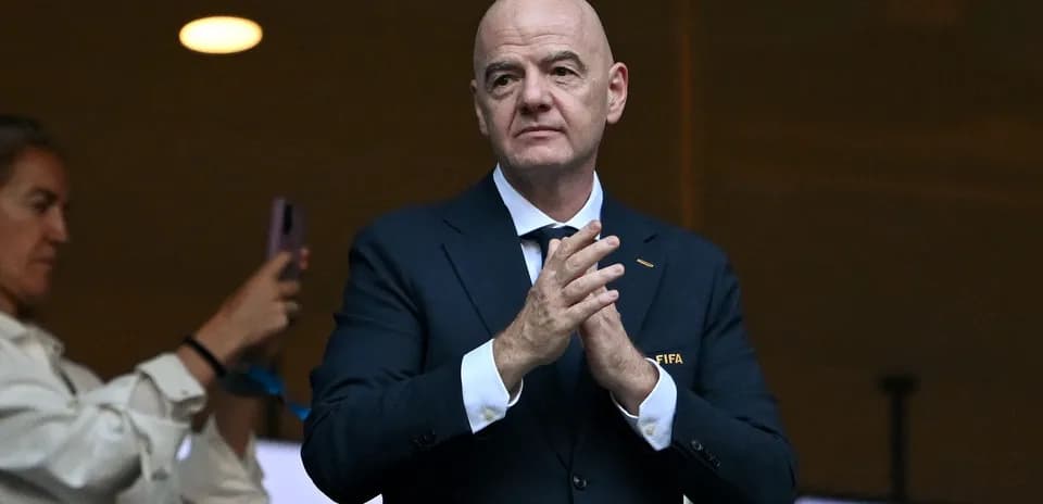 FIFA official clapping in a stadium box