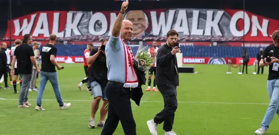 Coach waving with flowers on the pitch