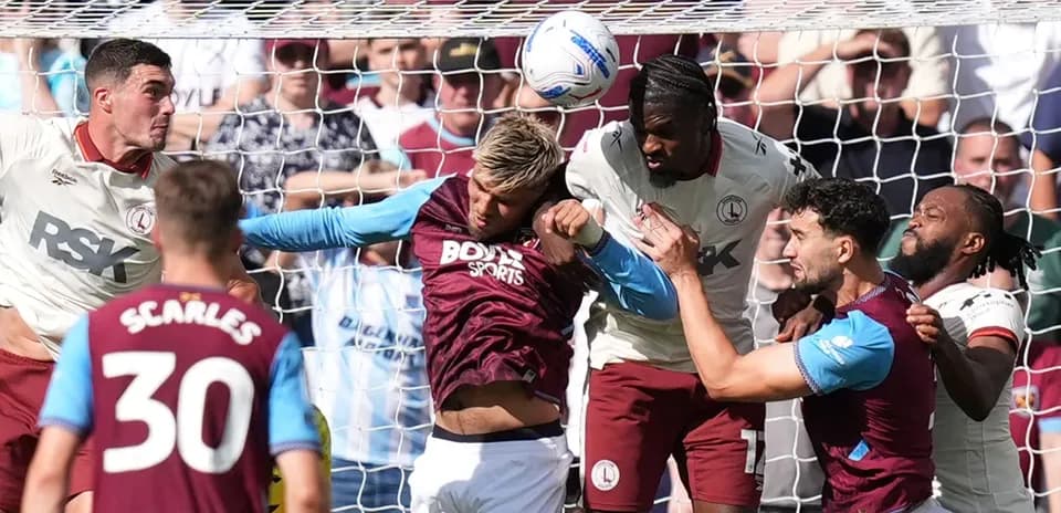 Players contesting a header in front of goal