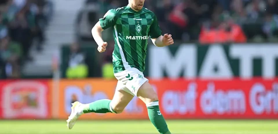 Player in green kit running with soccer ball