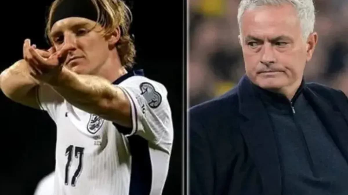 Player celebrating goal alongside coach during match
