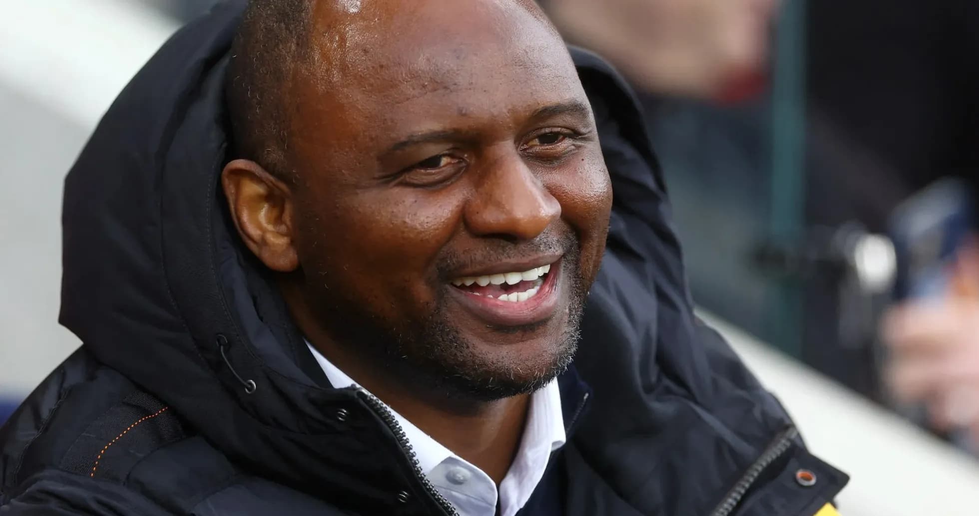 Man smiling in a sports jacket during event
