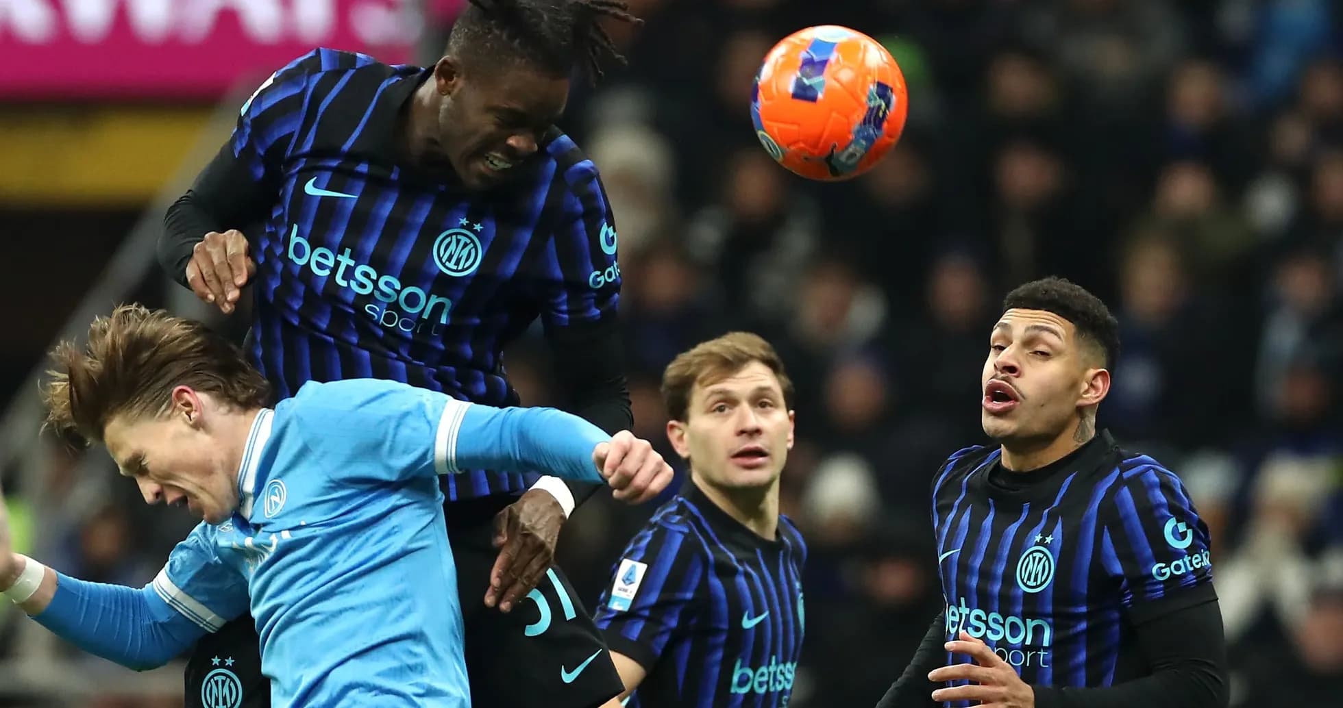 Players contesting a header during a football match