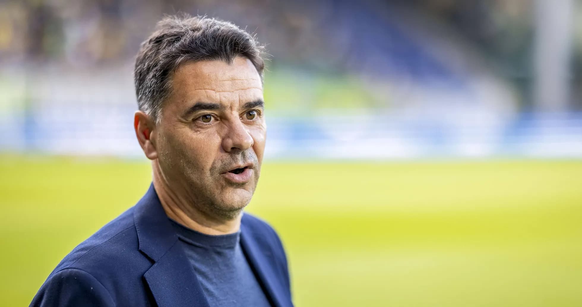 Coach speaking during pre-match event on the field