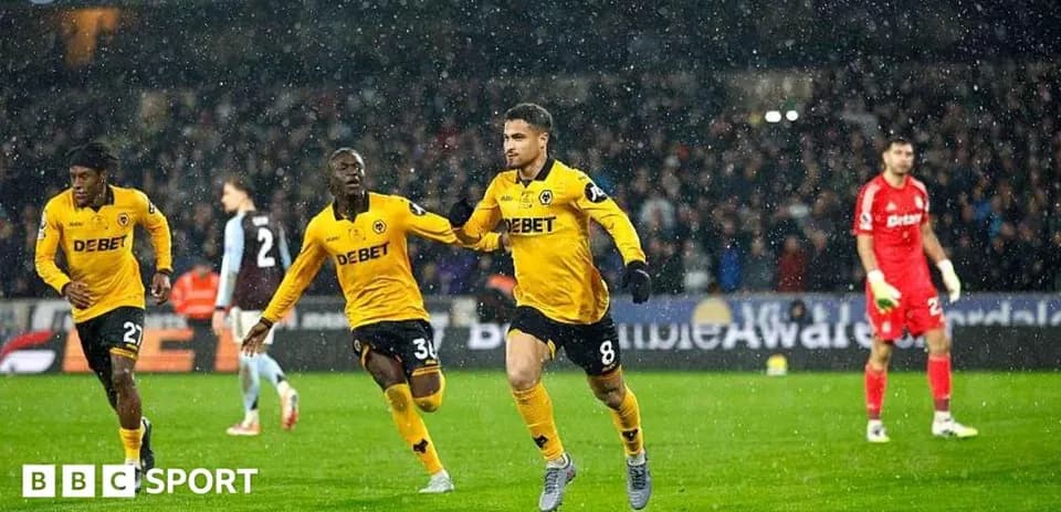 Player celebrating goal in rainy football match
