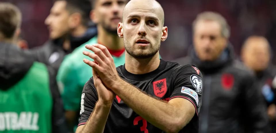 Player in Albania jersey applauding fans after match