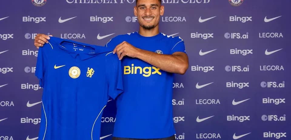 Player holding Chelsea FC jersey at press conference