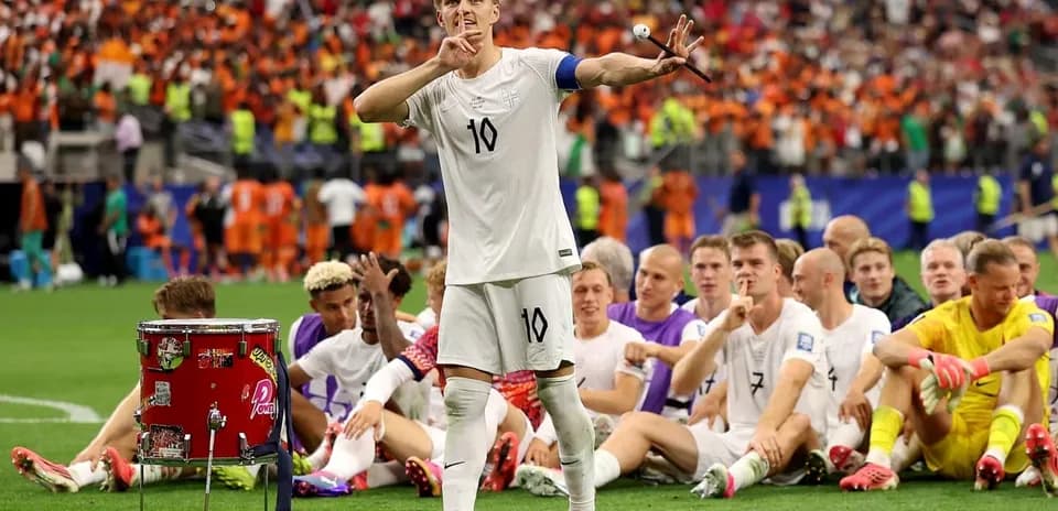 Player gesturing to crowd with teammates seated behind