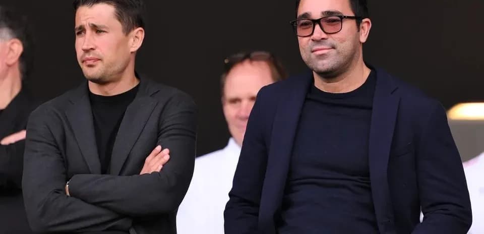 Two men sitting in stands during a match