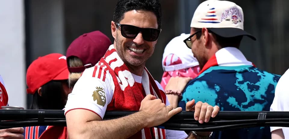 Man in sunglasses smiling with Arsenal scarf