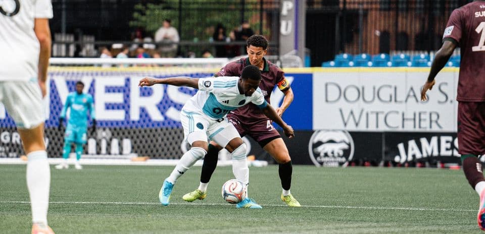 Players contesting the ball in MLS Next Pro match