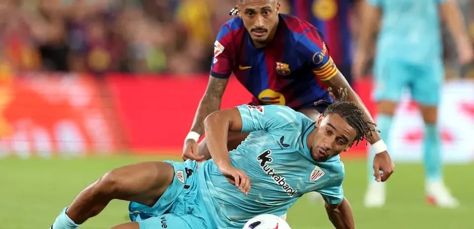 Barcelona player challenging Athletic Club player for ball