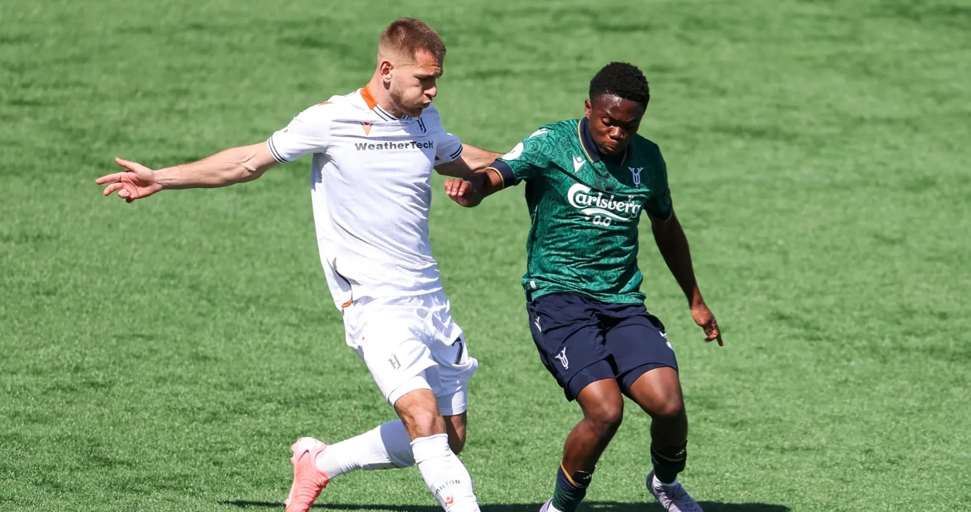 Two players competing for the ball in football