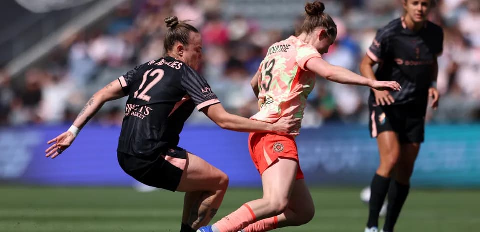 Player tackling opponent during NWSL match