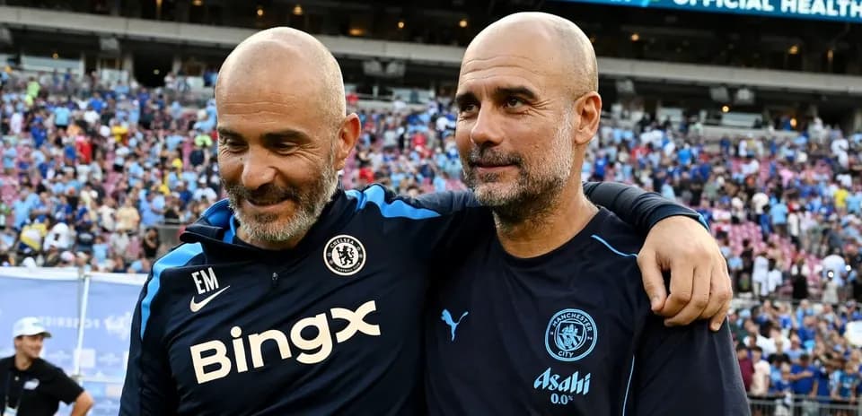 Two football coaches embracing after a match
