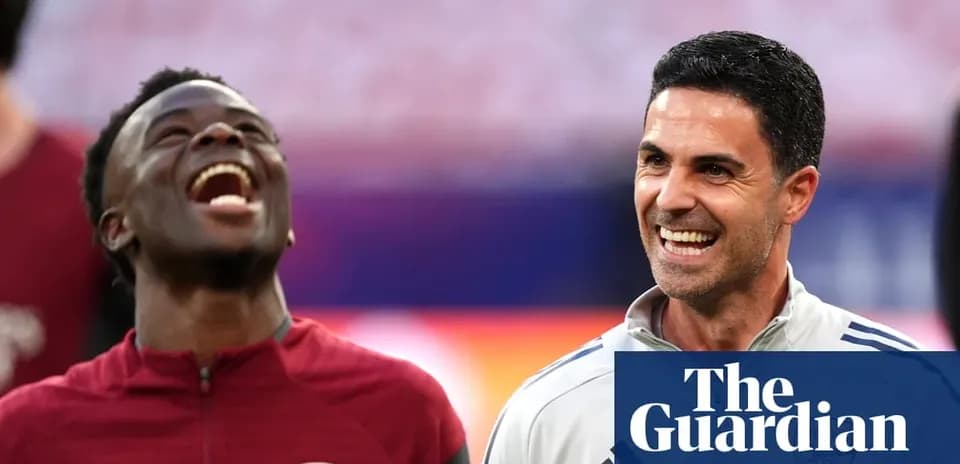 Two Arsenal staff members smiling during training session