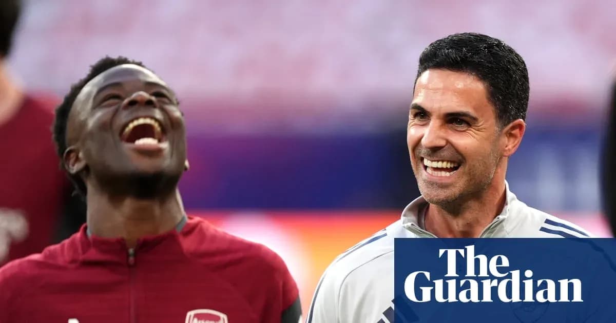 Two Arsenal staff members smiling during training session