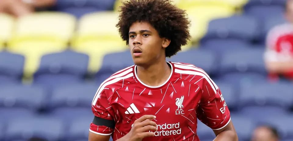 Player in Liverpool kit warming up on pitch