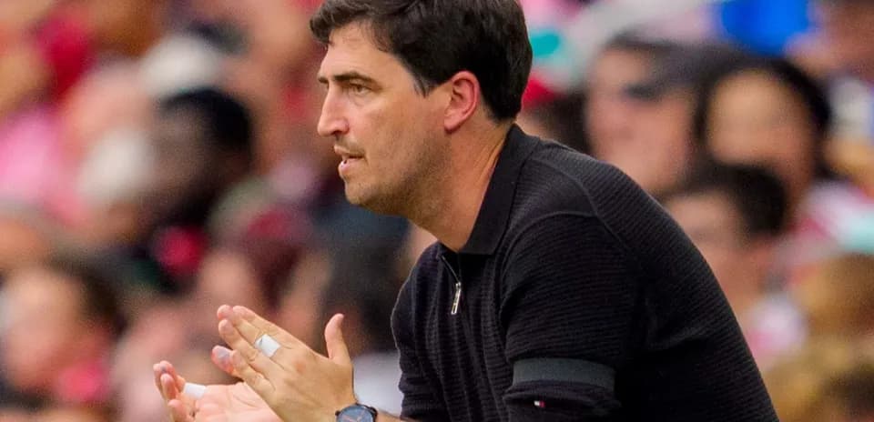 Coach clapping and instructing from the sidelines