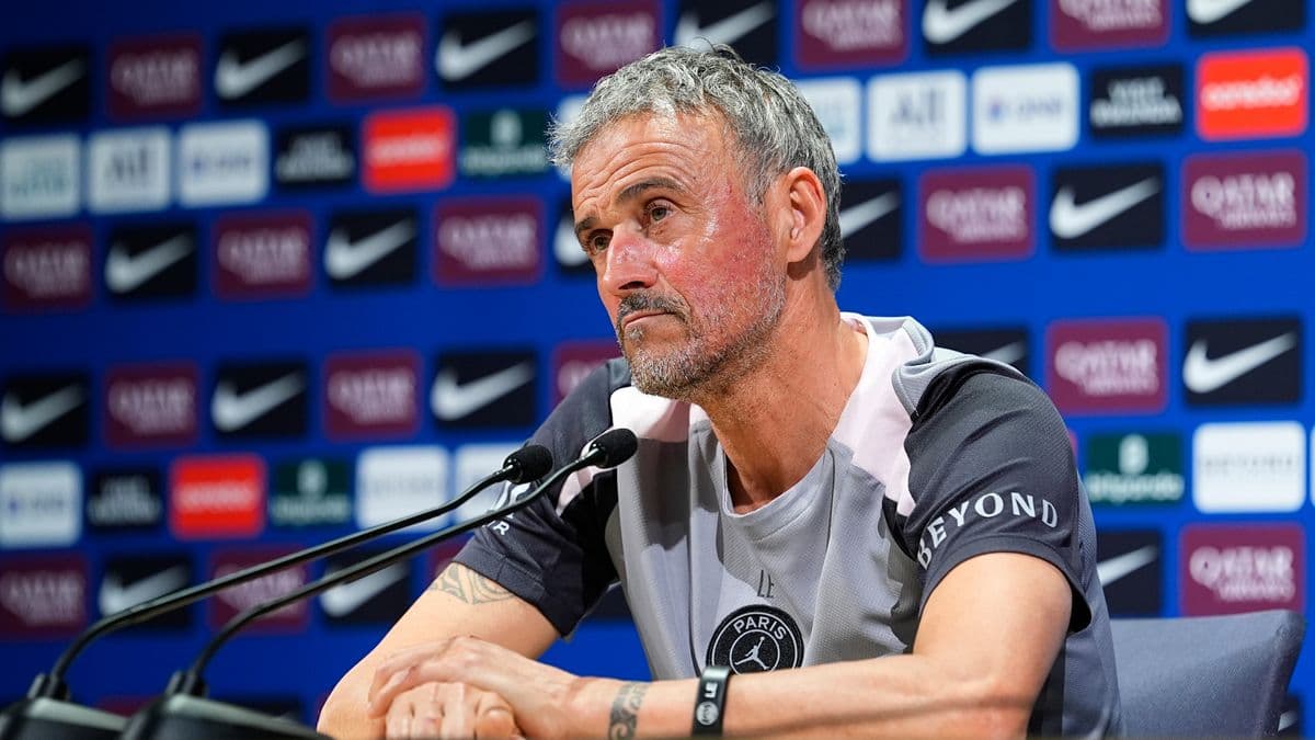Manager at press conference with sponsor backdrop