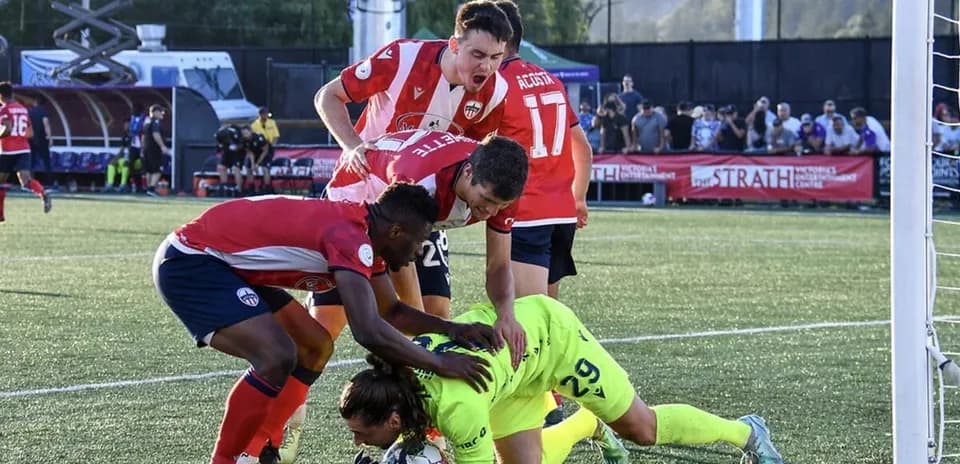 Players competing for the ball in football match