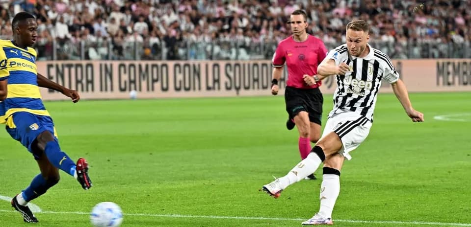 Juventus player shooting against Parma defender