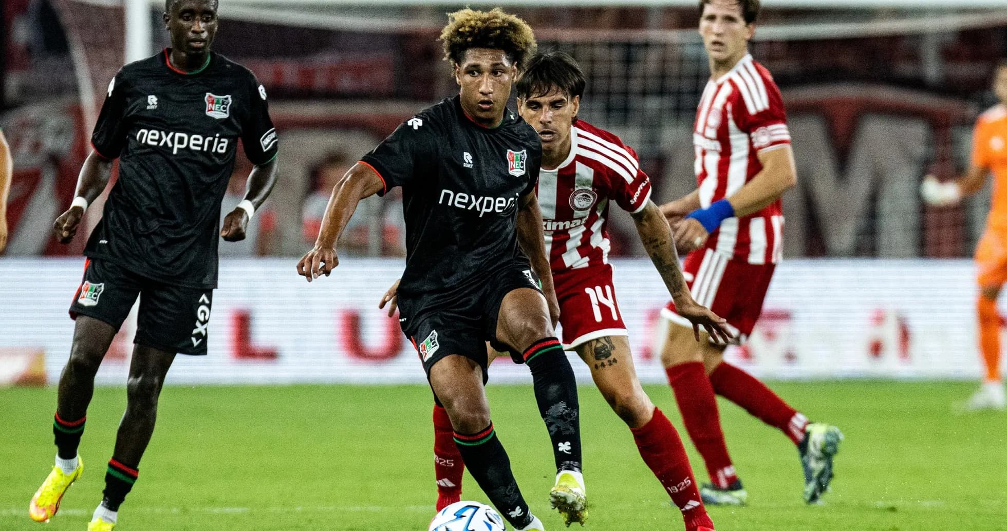 NEC Nijmegen player dribbling past Olympiakos defender