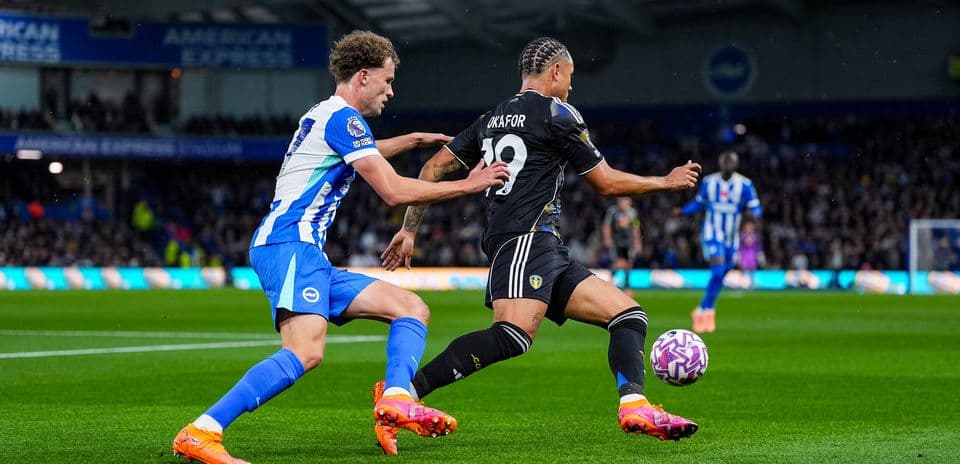 Player from Leeds avoiding tackle by Brighton player