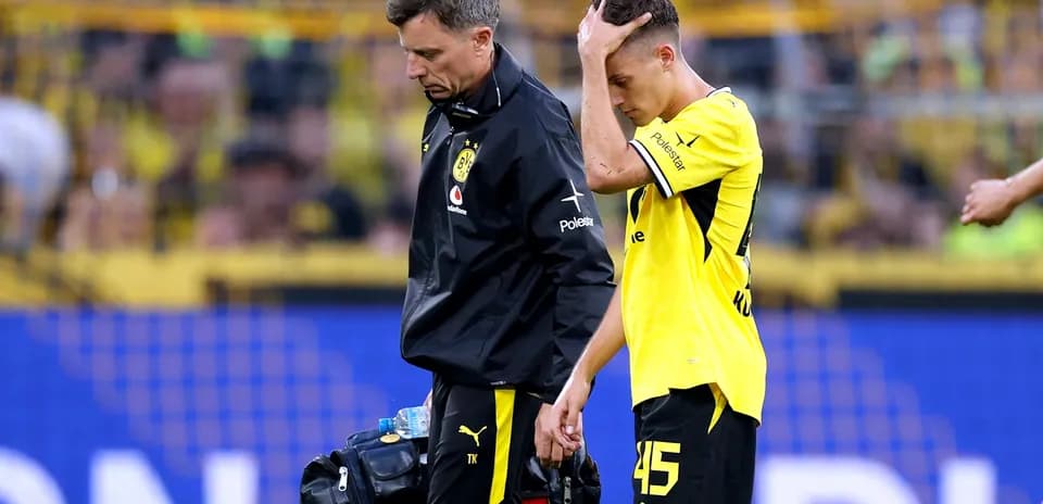 Player receiving assistance from medical staff after injury
